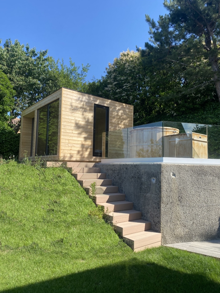 Un petit bâtiment en bois situé au sommet d’une colline verdoyante.