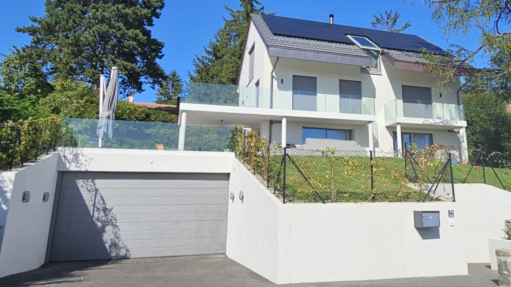 Une maison avec un toit vert et une clôture