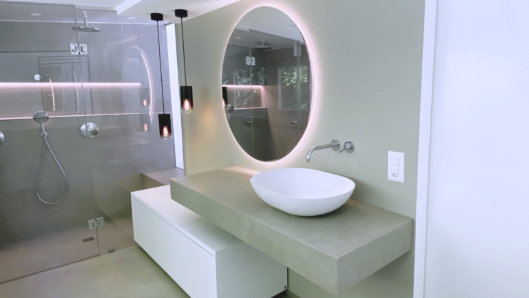 Une salle de bain avec lavabo, miroir et douche